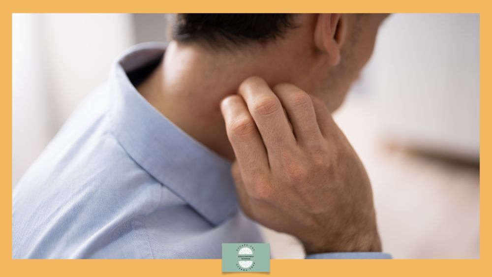 Eczema in men - man in blue shirt scratches the back of his neck.